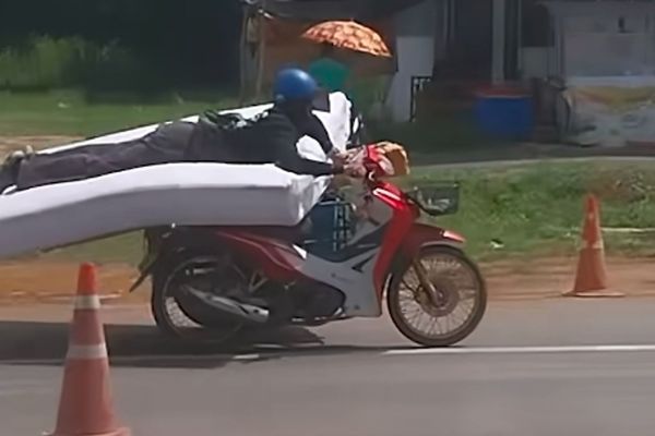 d8230914 一名男子趴在床墊上騎機車,姿勢相當特殊,引起網友熱烈討論。(翻攝畫面)