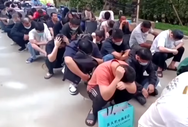 ▲▼KK園區數百名被捕的外籍嫌犯提著行李、整齊坐在道路兩側。（圖／翻攝自YouTube／The Star）