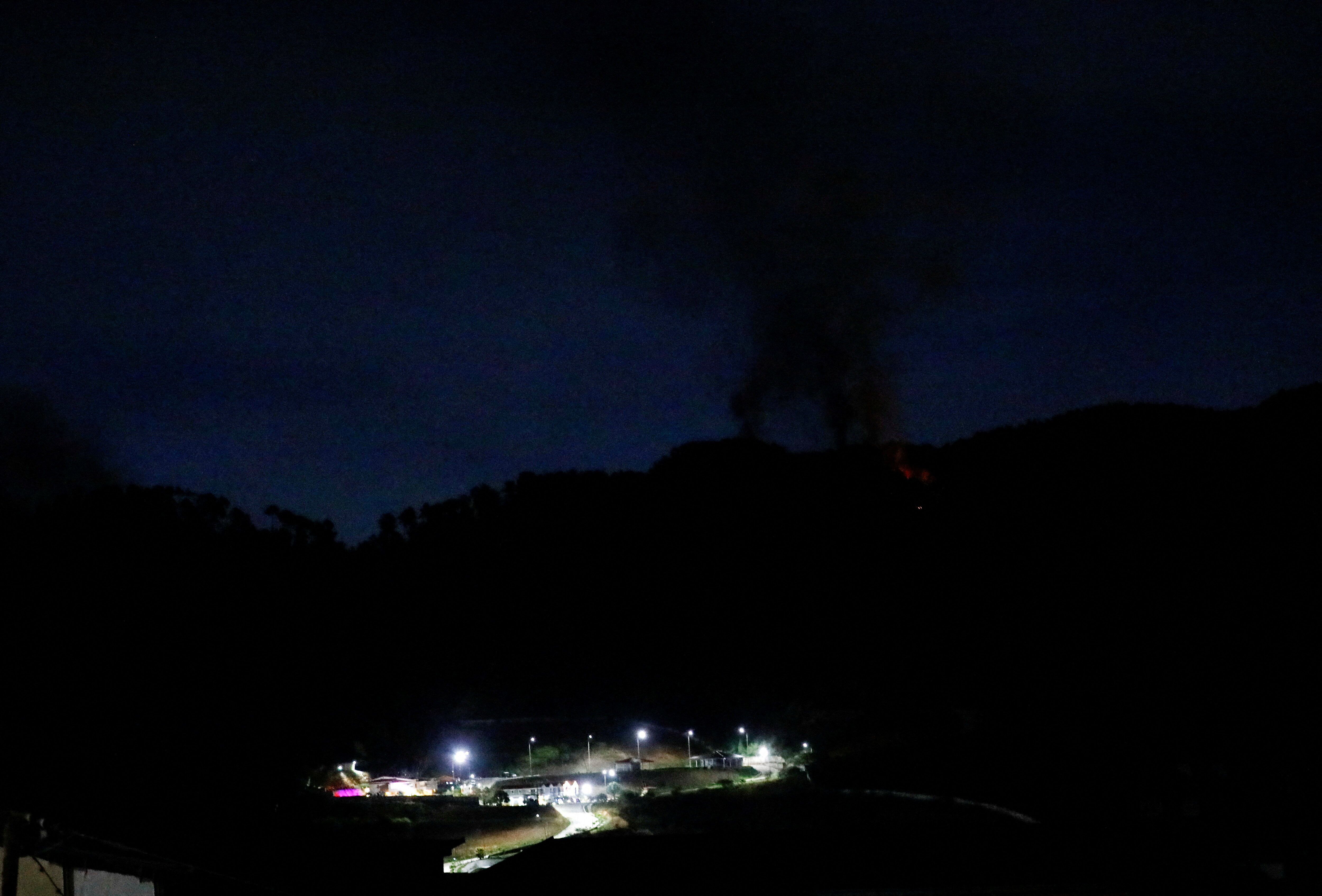 8565015 ▲▼ 委內瑞拉首都卡拉卡斯發生多起爆炸,重要軍事設施蒂烏納堡(Fort Tiuna)發生停電,一片漆黑中竄起濃煙。(圖/路透)