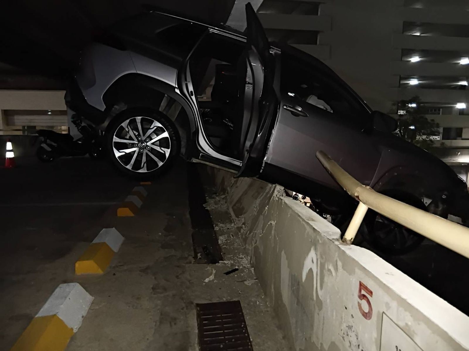 停車場驚魂！駕駛誤踩油門衝破牆　懸掛3樓高空「奇蹟死裡逃生」