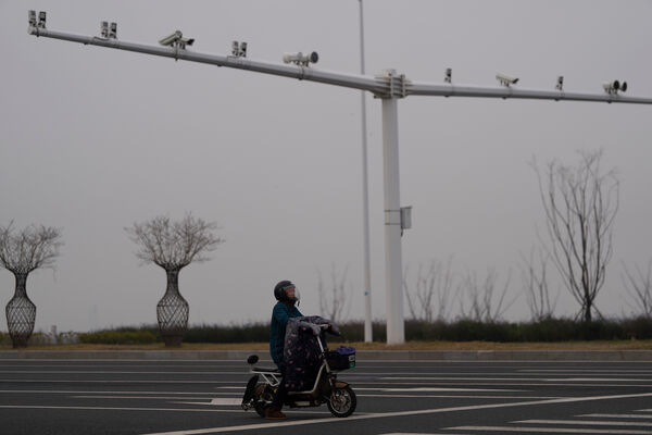d8728693-1 ▲▼ 中國一名機車騎士停在路口,頭上有一整排監視器。(圖/達志影像/美聯社)
